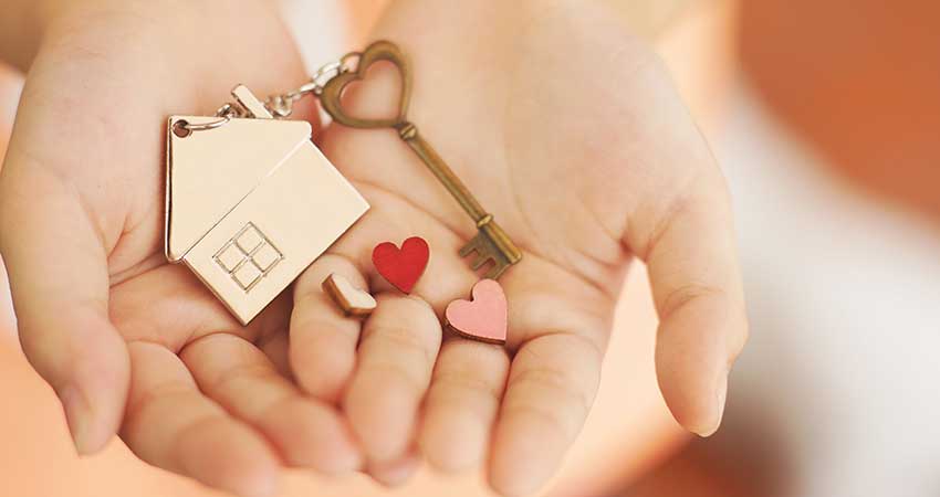 hands holding house keychain